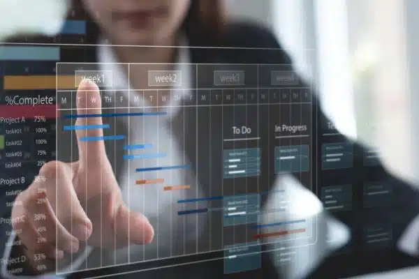 Cómo utilizar una matriz de gestión del tiempo + plantilla gratuita Una mujer que planifica proyectos en una plataforma de gestión de proyectos